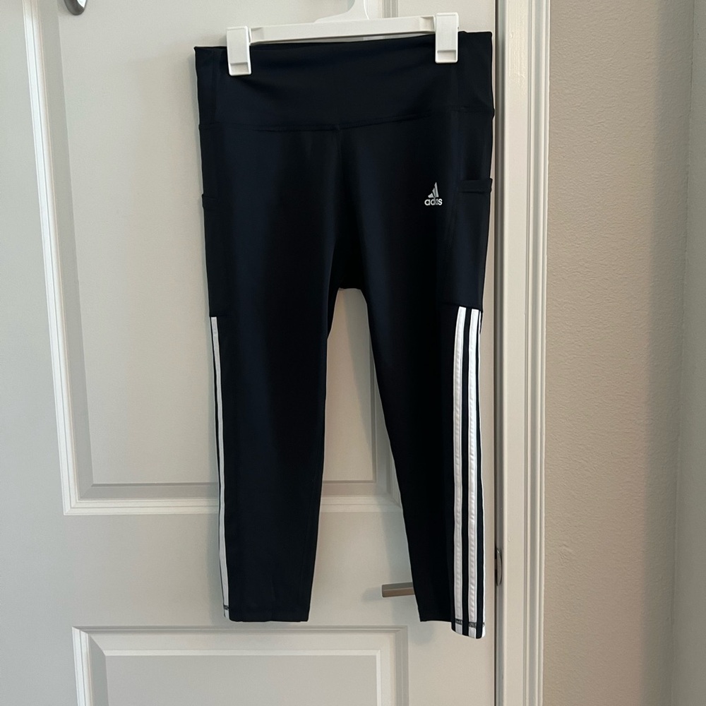 Never worn Adidas leggings with white strips on side.